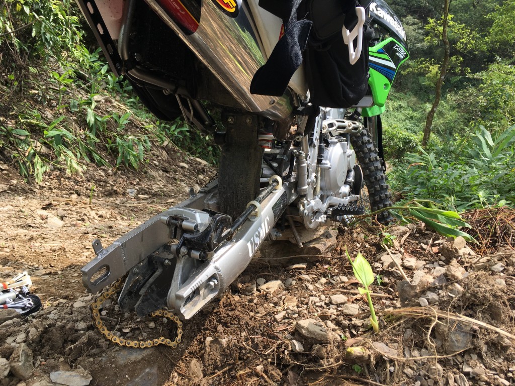 Motorcycle with no rear tire sitting in dirt