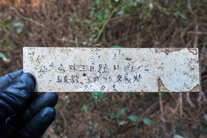 寫有中文的白色塑膠牌 - 武潭山山頂