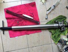 Motorcycle fork and spring on towel on tile floor